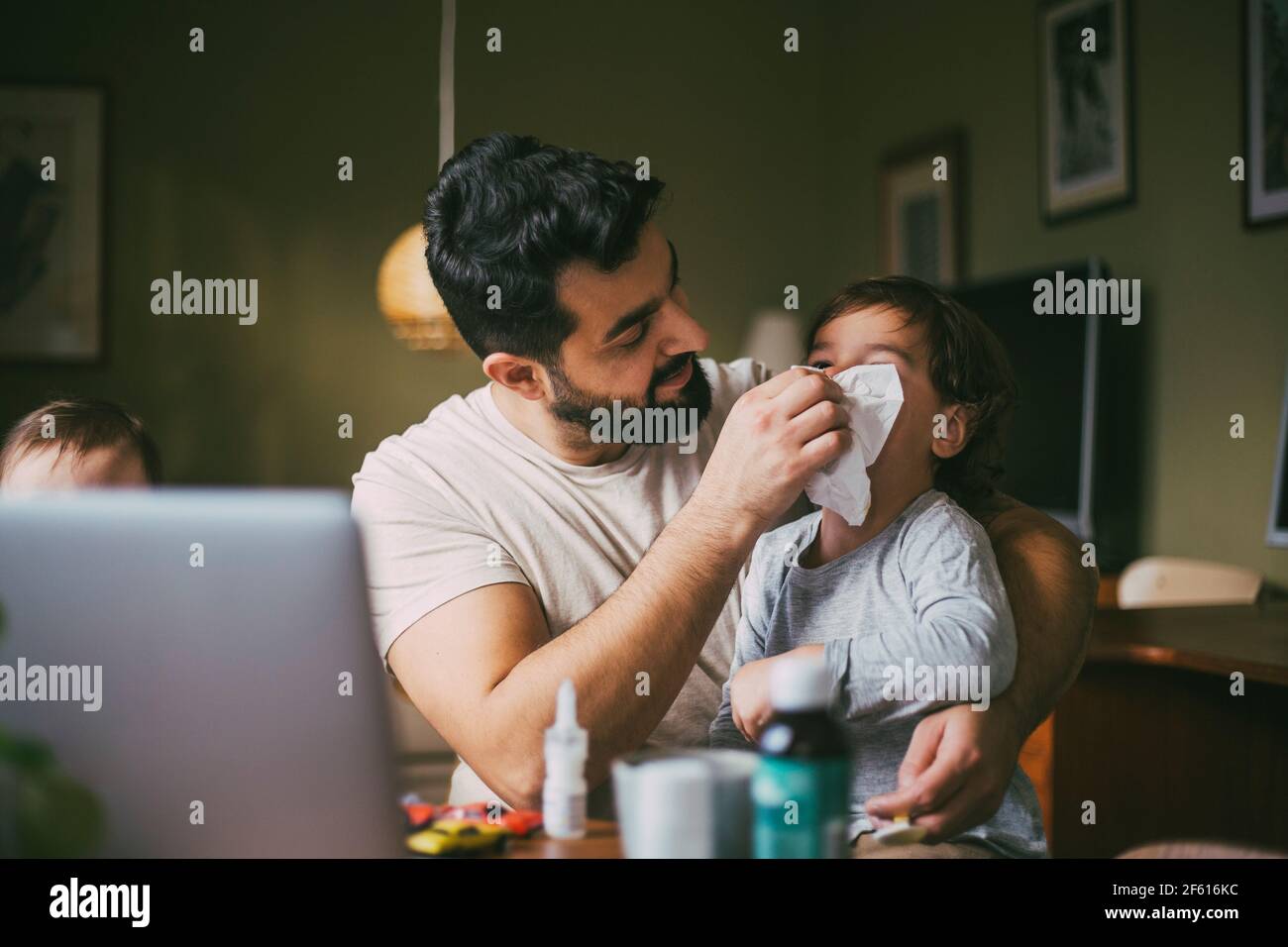 Vater bläst Nase des Sohnes im Wohnzimmer Stockfoto
