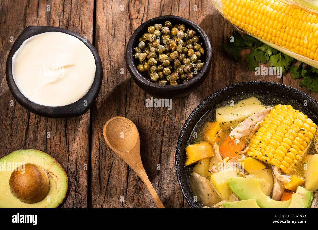 Hühnersuppe mit Kartoffeln. Kolumbianische Küche. Auf spanisch klingt es wie 'Ajiaco'. Lateinamerikanische Küche. Serviert mit Avocado, Kapern, Limette, Koriander Stockfoto