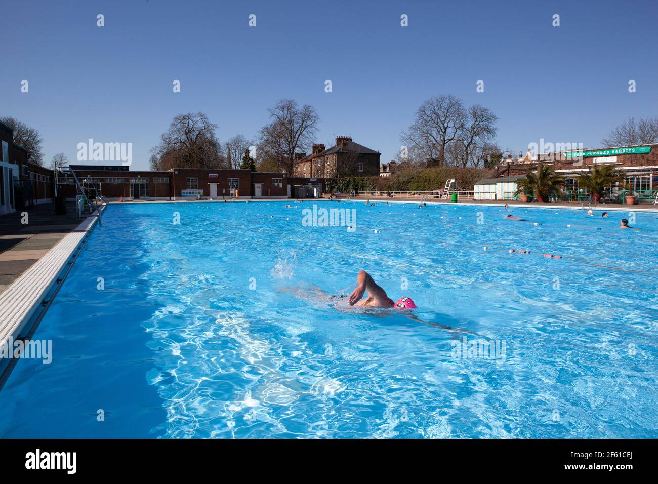 London, Großbritannien, 29. März 2021: Brockwell Lido wurde heute wiedereröffnet, da die Sperre in England nachlässt. Schwimmer jeden Alters nutzten die Sonne, um das Wasser bei kühlen 9,8 Grad zu trotzen. Das Lido wird von Fusion Lifestyle für den Lambeth Council betrieben, die kovide Sicherheitsmaßnahmen und ein Einbahnsystem implementiert haben, um soziale Distanzierung zu gewährleisten. Anna Watson/Alamy Live News Stockfoto