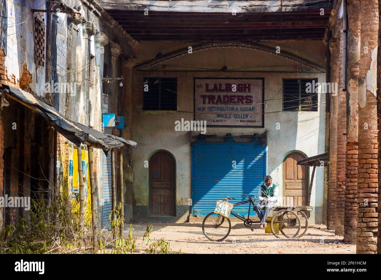 Murshidabad, Westbengalen, Indien - Januar 2018: Ein älterer Inder sitzt auf einem fahrbaren Wagen in den Ruinen eines verlassenen Marktes in der Stadt Murs Stockfoto