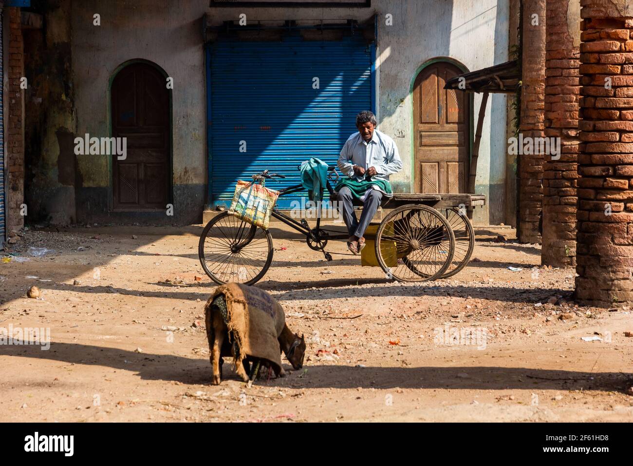 Murshidabad, Westbengalen, Indien - Januar 2018: Ein älterer Inder sitzt auf einem fahrbaren Wagen in den Ruinen eines verlassenen Marktes in der Stadt Murs Stockfoto