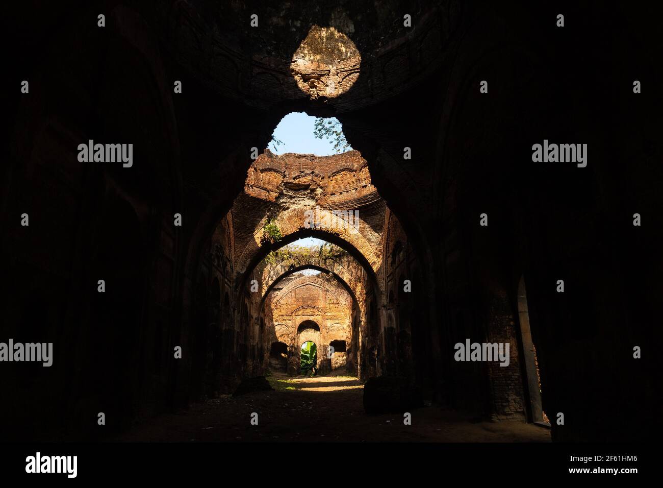 Die überwucherten Ruinen einer alten Festung mit eleganten Bögen in der Stadt Murshidabad in Westbengalen, Indien. Stockfoto