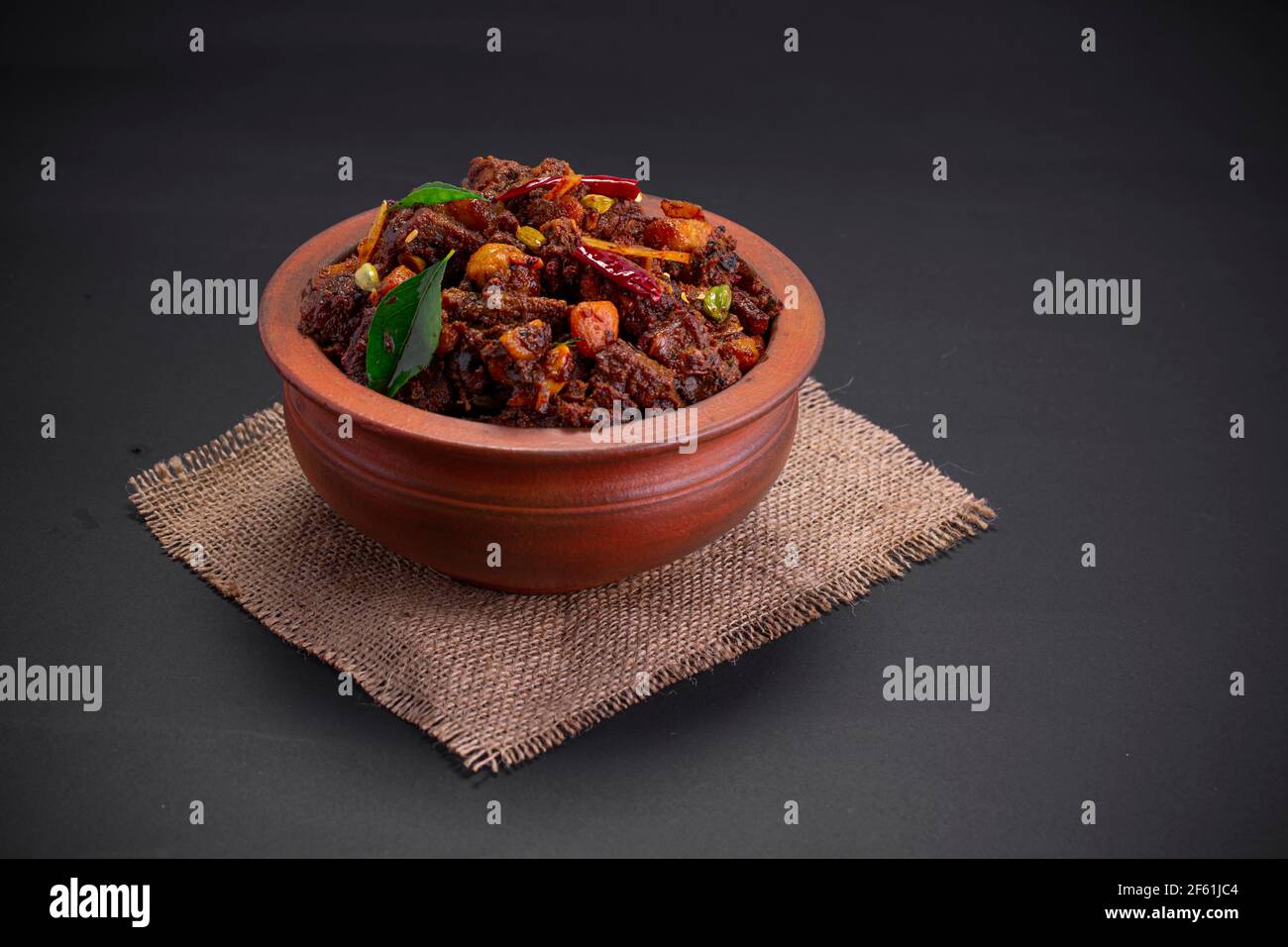 Rinderbraten oder Pothu ulartheyadu, kerala Spezialgericht in einem Steingut in traditioneller Weise mit Kokosnussstücken garniert angeordnet. Stockfoto