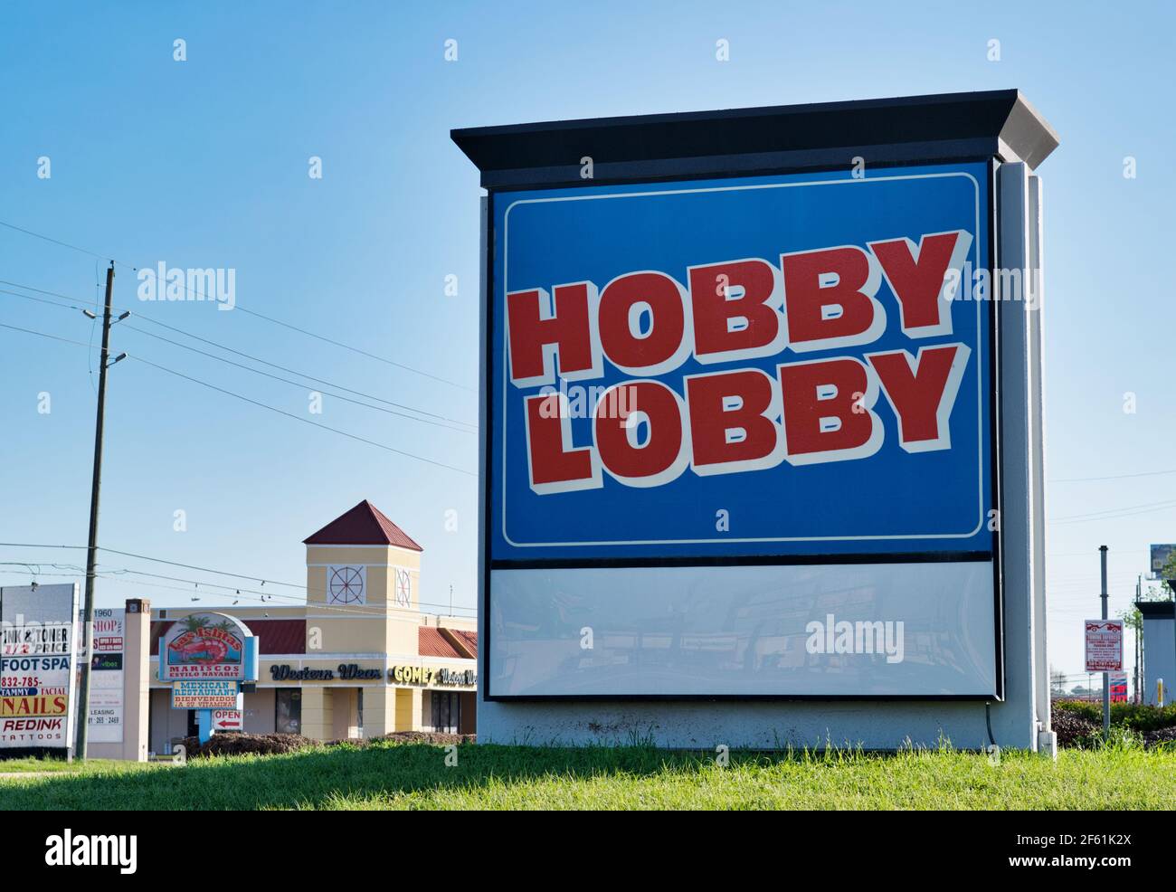 Houston, Texas USA 03-26-2021: Hobby Lobby Straßenschild mit lokalen Unternehmen im Hintergrund. Amerikanisches Kunsthandwerksgeschäft, gegründet 1972. Stockfoto