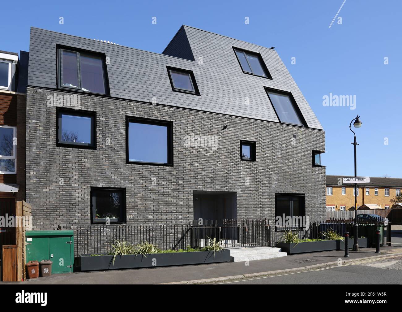 Markante neue Wohnblock an der Costa Steet, Peckham durch WAS Architektur. Mit dunklem Mauerwerk, schwarzen Fenstern und nach außen geneigtem Mansardendach. Stockfoto