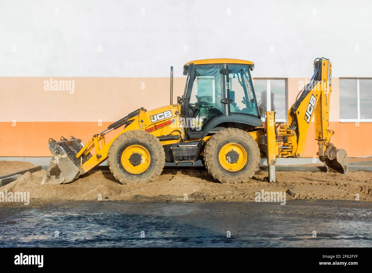 Weißrussland, Minsk - 19. Dezember 2019: Industriebagger auf dem Hintergrund eines modernen Gebäudes auf einer Baustelle. Stockfoto