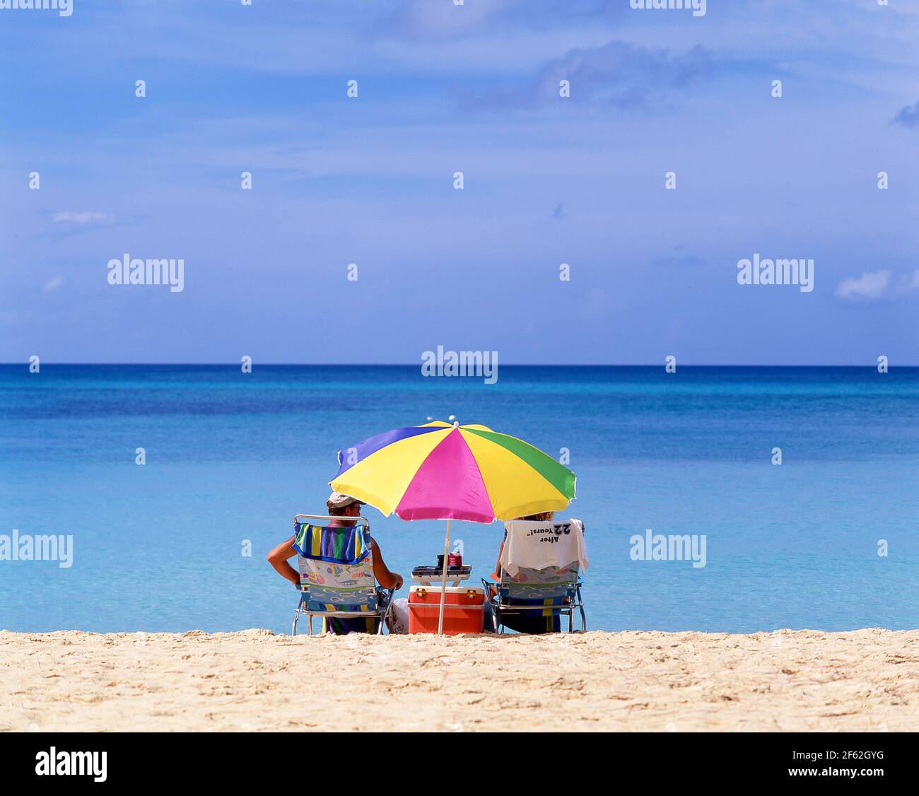 Ältere Ehepaare sitzen am Strand, Seven Mile Beach, West Bay, Grand Cayman, Cayman-Inseln, Großantillen, Karibik Stockfoto