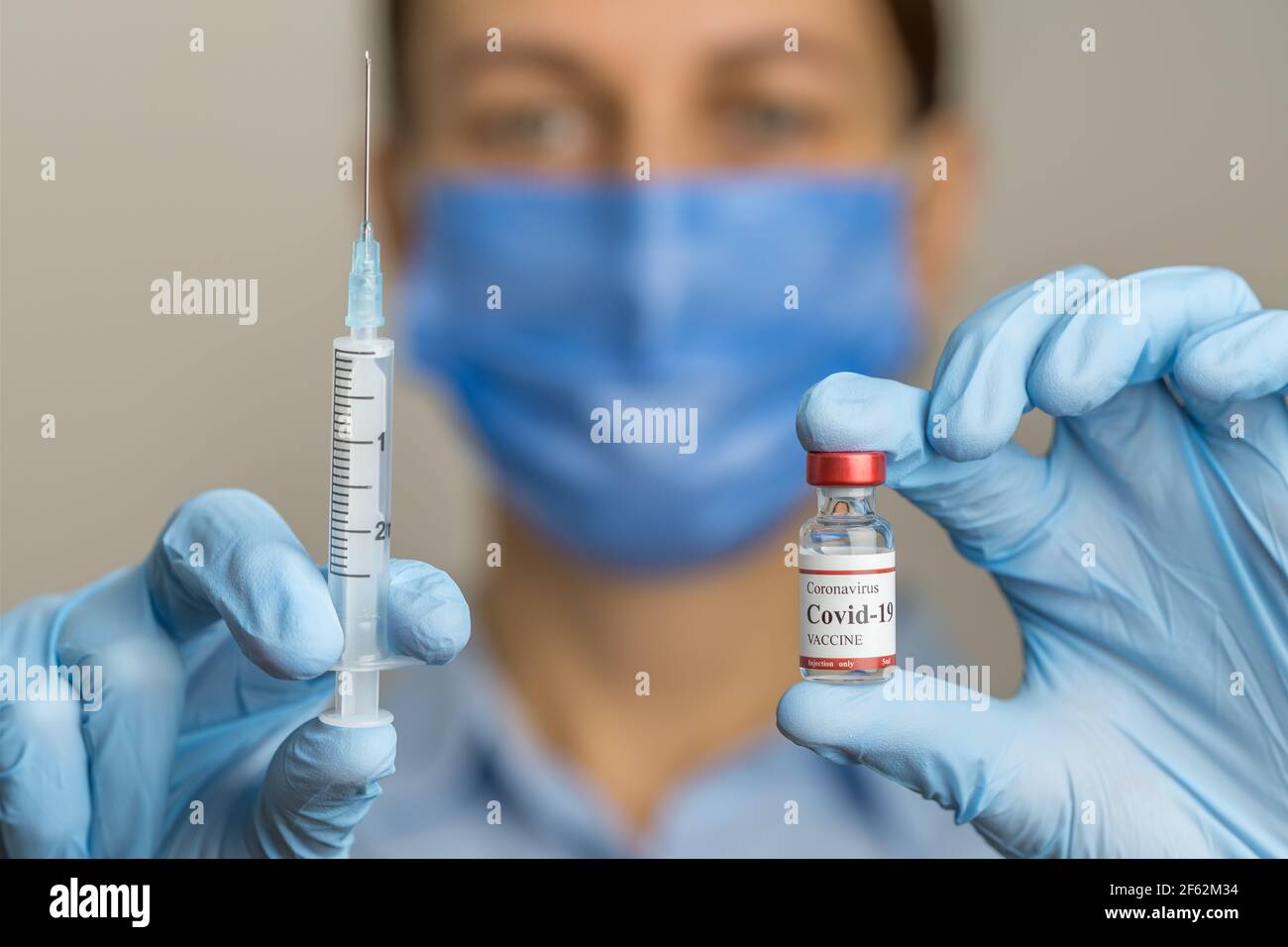 Ärztin hält Spritze und Coronavirus-Impffläschchen. Stockfoto