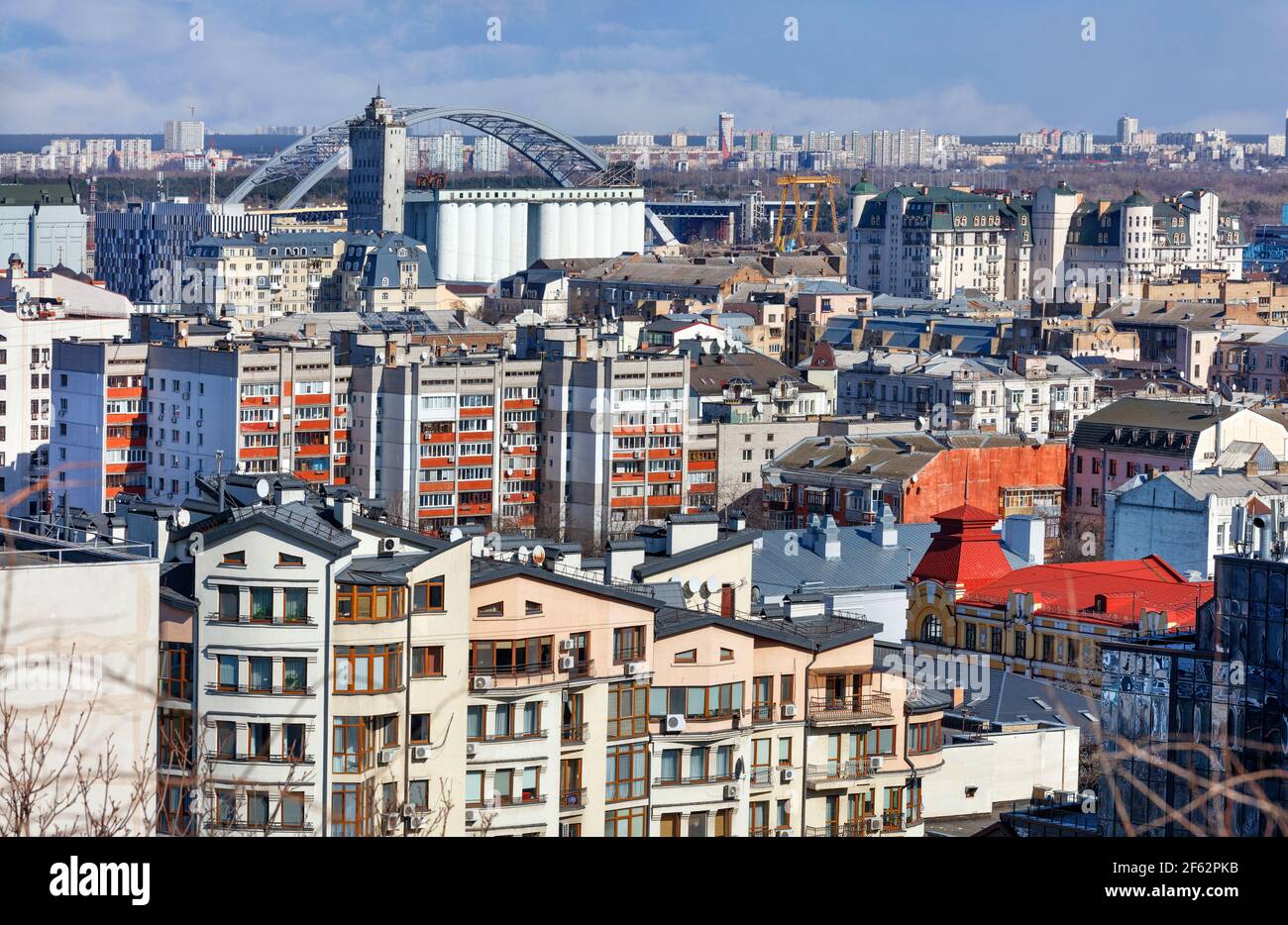 Dichte Entwicklung des alten Bezirks Podil in Kiew vor dem Hintergrund einer Brücke über den Fluss und Häuser von Wohngebieten. Stockfoto