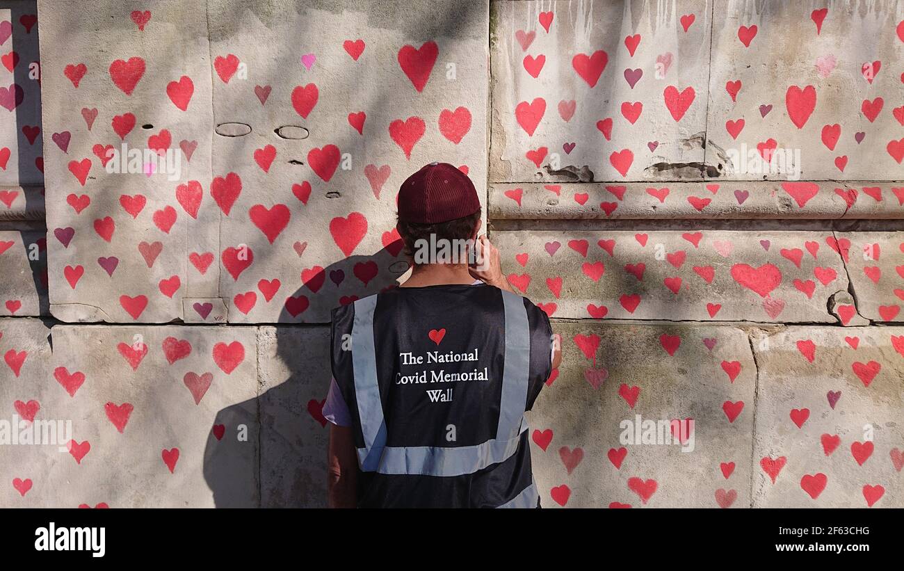 London, Großbritannien. 29th, März 2021. Trauerte Familie und Freunde werden von Keir Starmer besucht, als sie Herzen auf die Covid Memorial Wall malen. Stockfoto