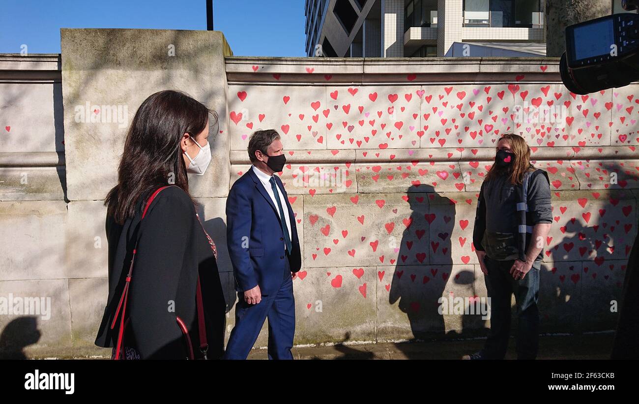 London, Großbritannien. 29th, März 2021. Trauerte Familie und Freunde werden von Keir Starmer besucht, als sie Herzen auf die Covid Memorial Wall malen. Stockfoto