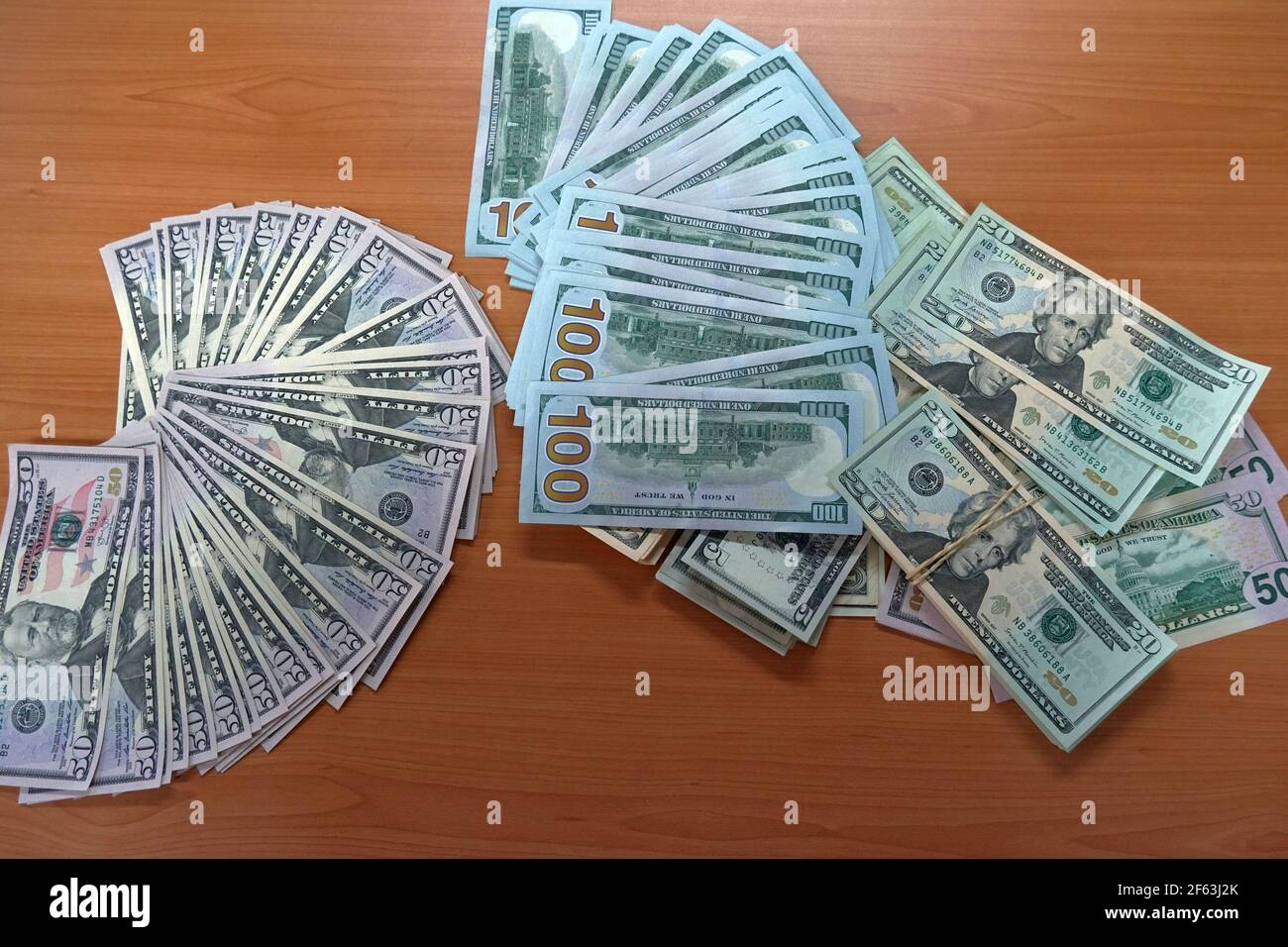 US-Dollar-Banknoten, Papiergeld oder grüne Rücken breiten sich in verschiedenen Nominalwerten auf dem Tisch aus. Stockfoto