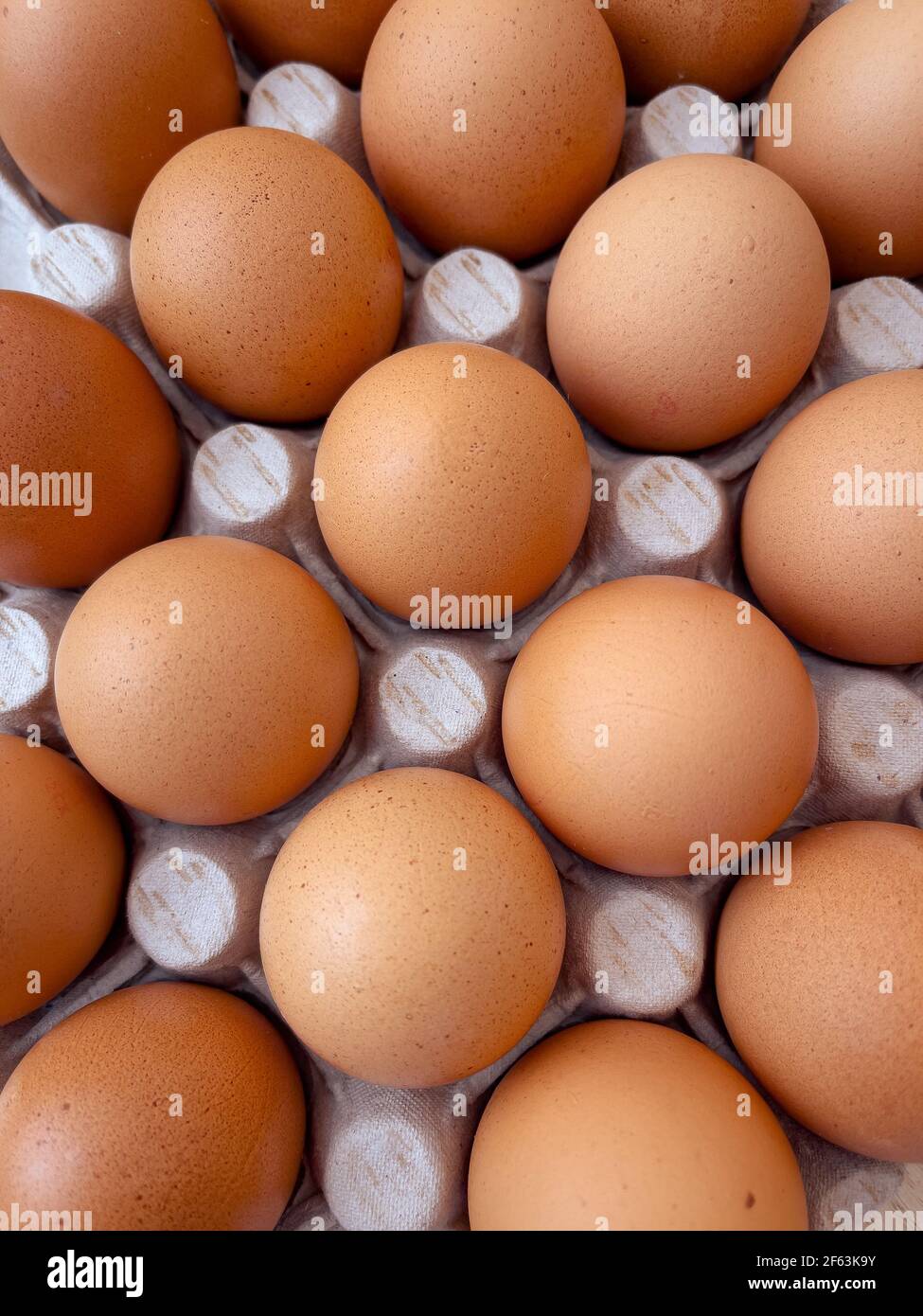 Eier in Eierkarton braun anbraten. Draufsicht auf rohe Bio-Hühnereier im Karton. Stockfoto