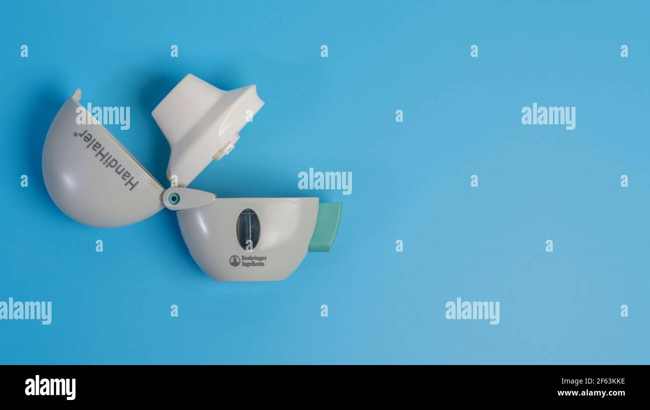 COPD oder Asthma Medikationsgeräte, Diskus und Handihaler auf blauem Hintergrund. Stockfoto