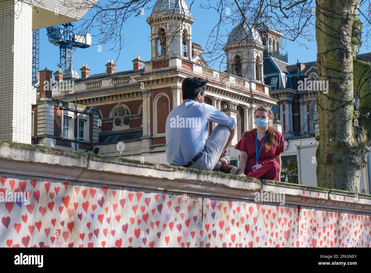 St. Thomas's Hospital, London, Großbritannien. 29th. März 2021. Die Hinterbliebenen und Freiwilligen malen Herzen für jede Person, die an Covid gestorben ist. Medizinisches Personal aus dem Krankenhaus sitzt und schaut über die Wand auf die Arbeit. Kredit: Denise Laura Baker/Alamy Live Nachrichten Stockfoto