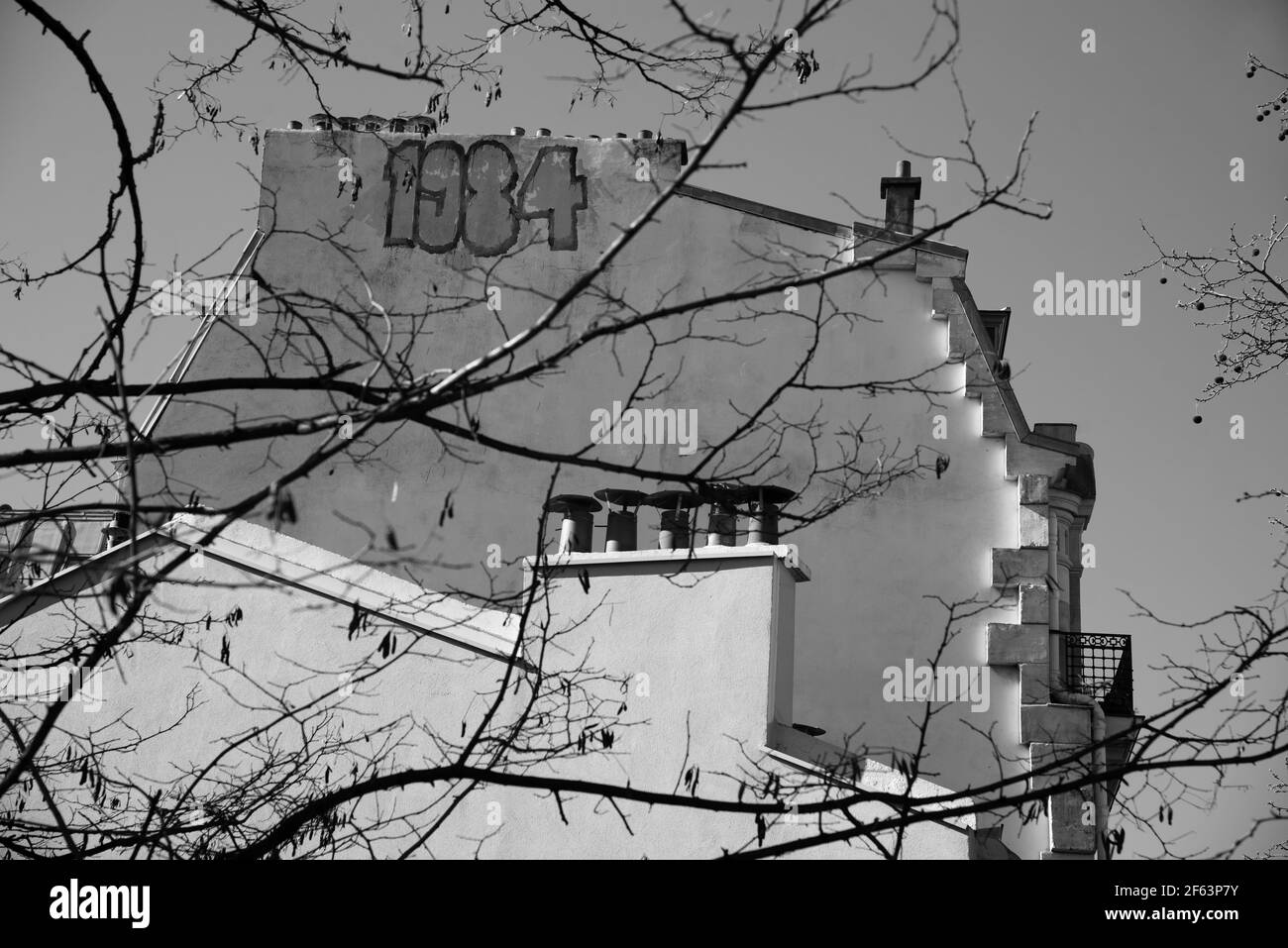 PARIS, FRANKREICH - 6. MÄRZ 2021: 1984 neunzehn vierundachtzige Graffiti an der Wand eines typischen Pariser Wohnhauses. Schwarz weiß historisches Foto Stockfoto