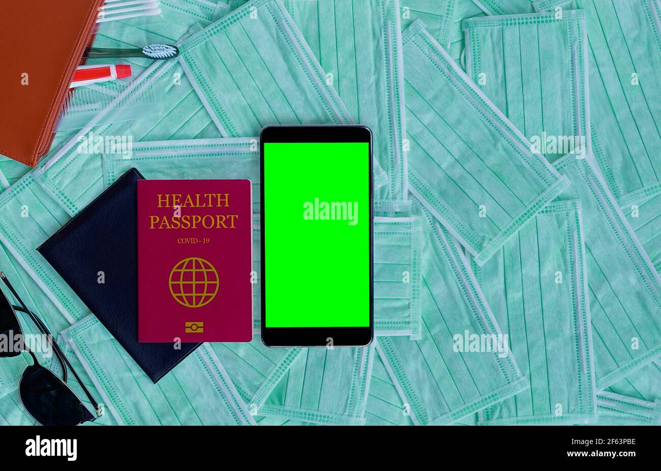 Reisepass und Smartphone mit grünem Bildschirm. Reisekonzept mit Kopierplatz. Health Passport Corona Virus Impfstoff, Chroma Key Mockup Stockfoto