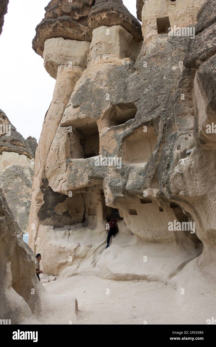 Manman betrachtet Höhlen, die aus Felsformationen Kappadokien, Türkei, geschnitzt wurden Stockfoto