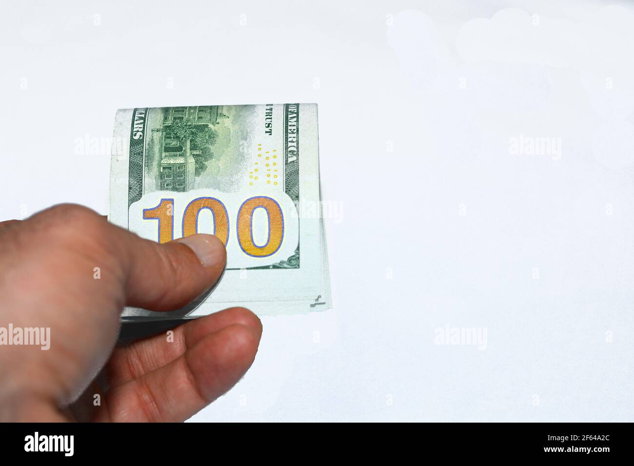 Nahaufnahme der Hand eines jungen Mannes, der 100-Dollar-Banknoten gibt Isoliert auf weißem Hintergrund Stockfoto
