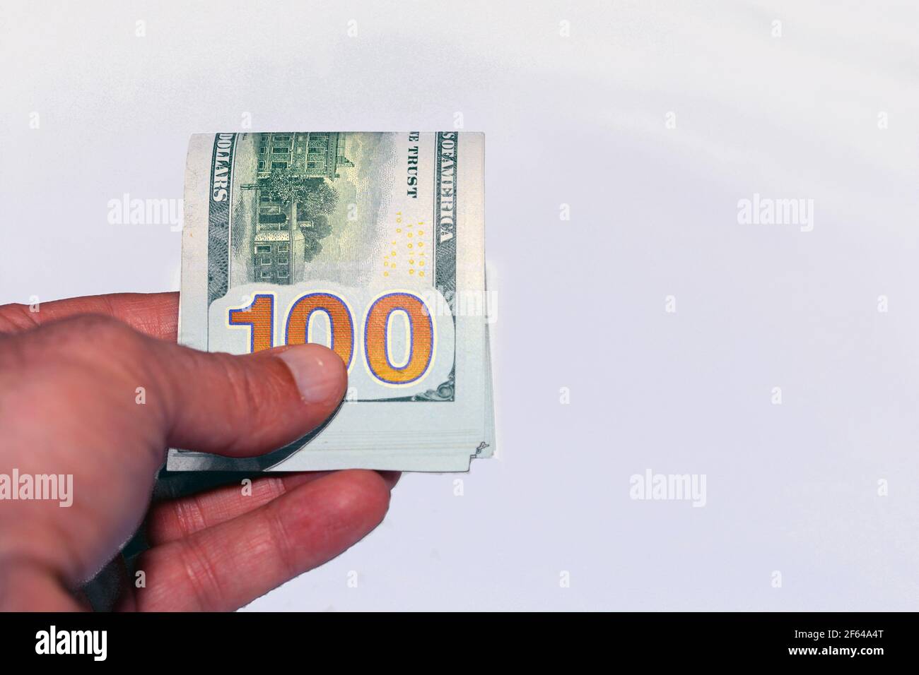 Nahaufnahme der Hand eines jungen Mannes, der 100-Dollar-Banknoten gibt Isoliert auf weißem Hintergrund Stockfoto