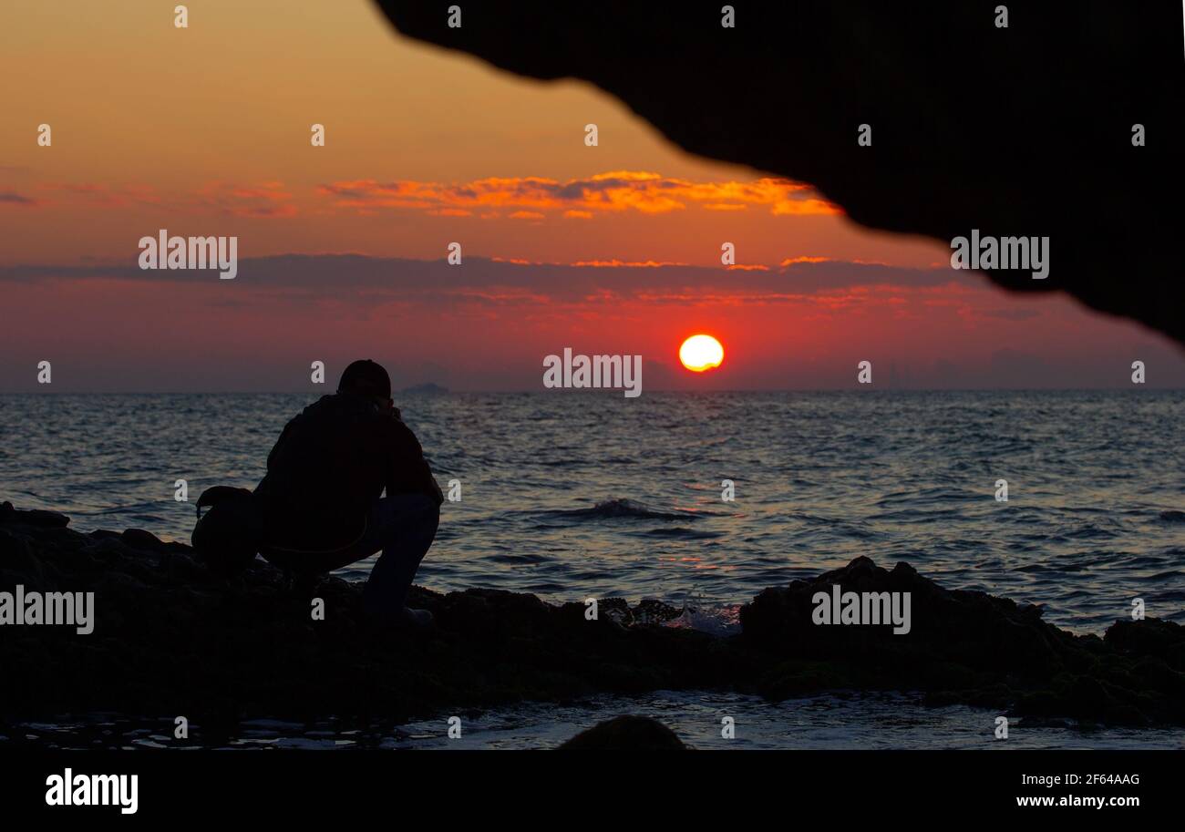 Fotograf fotografiert den Sonnenaufgang auf See. Stockfoto