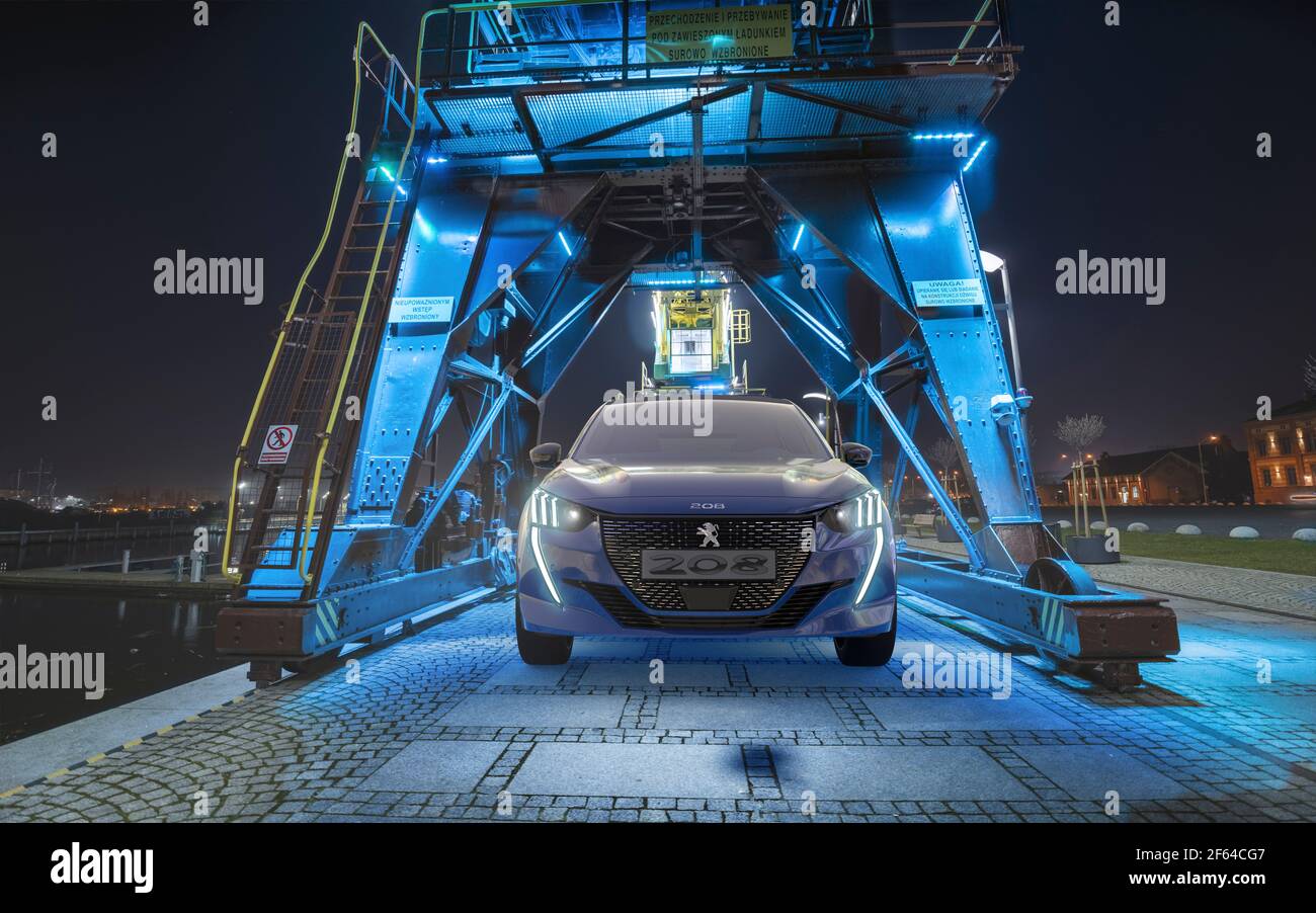 Neue elektrische Peugeot 208 beleuchtet durch Lichter der Hafenkrane Stockfoto