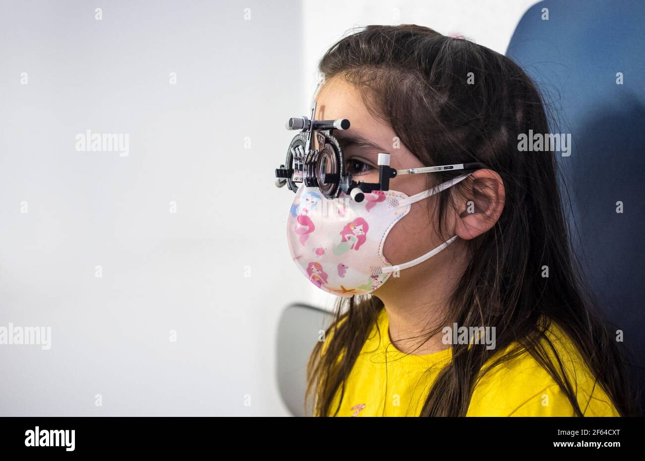 Kleines Mädchen tun Augentest bei Optiker. Kinder kümmern sich um Auge Konzept Stockfoto