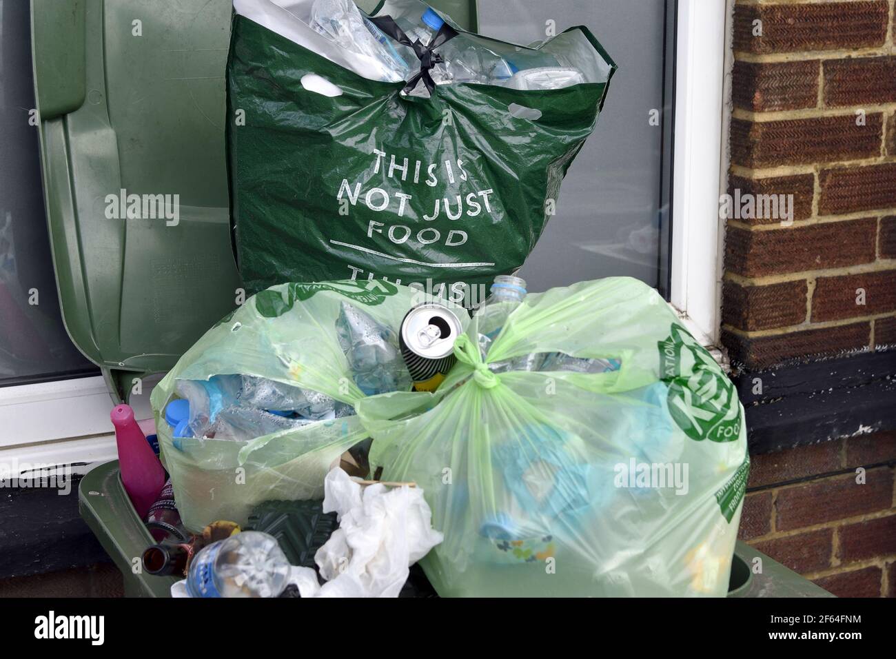 Maidstone, Kent, Großbritannien. Überlaufender Abfalleimer, mit Marken und Spencer-Tragetasche 'das ist nicht nur Essen...' Stockfoto