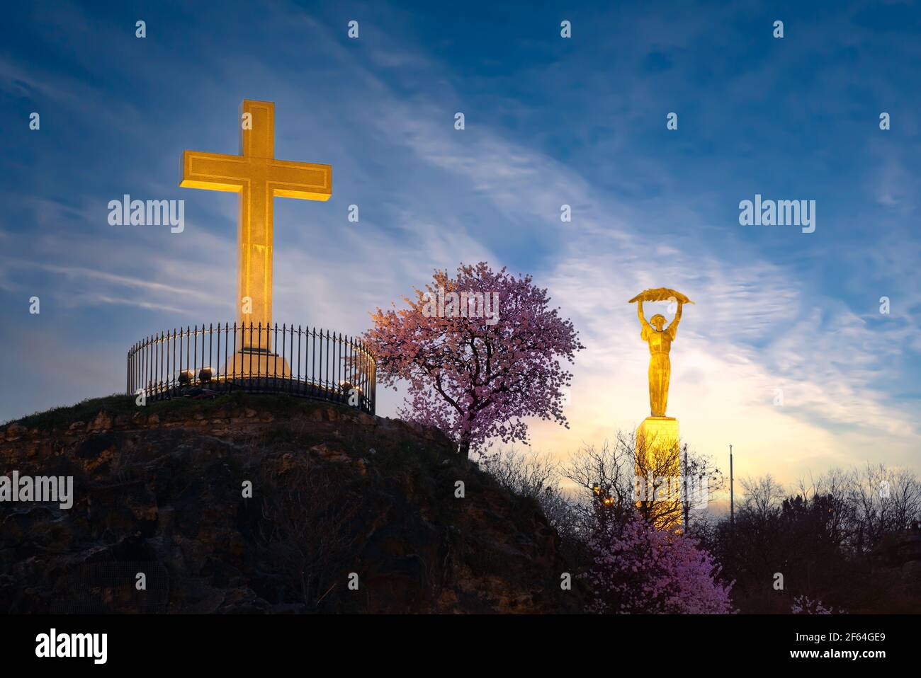 Christliches Kreuz mit blühendem Baum und Freiheitsstatue auf dem Hintergrund in Gellert Hill Budapest Ungarn Stockfoto