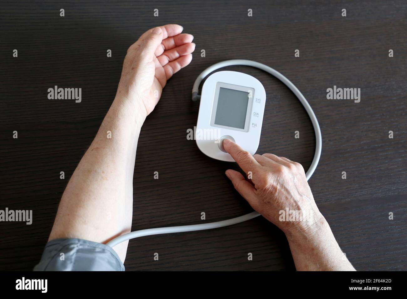 Ältere Frau misst den Blutdruck mit Blutdruck-Monitor. Alter, Gesundheitswesen und Kardiologie Konzept Stockfoto