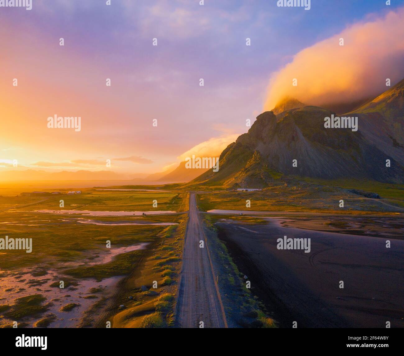 Schotterstraße bei Sonnenuntergang mit Vestrahorn Berg im Hintergrund, Island Stockfoto