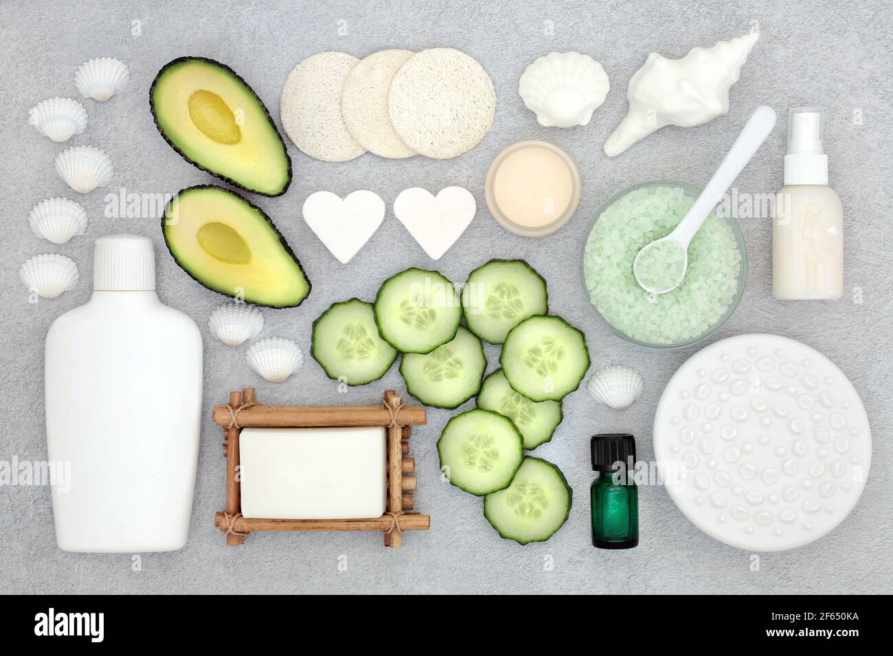 Natürliche Bio-Avocado & Gurken Beauty-Behandlungsprodukte für die Hautpflege mit veganen, grausamfreien Zutaten. Flach liegend auf meliertem grauen Hintergrund. Stockfoto