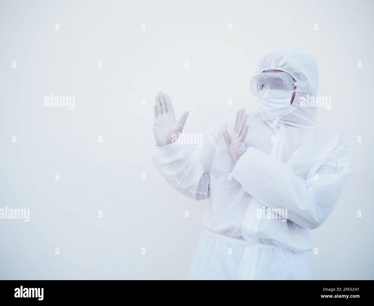 Asiatischer männlicher Arzt oder Wissenschaftler in PPE-Suite Uniform zeigt Stoppschild. Coronavirus oder COVID-19 Konzept isoliert weißen Hintergrund Stockfoto