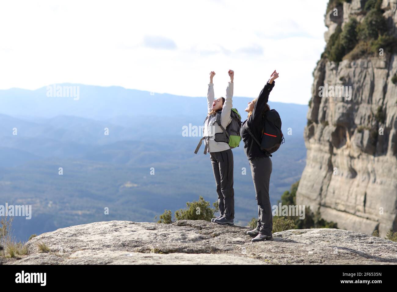 Zwei begeisterte Wanderer feiern Urlaub und heben die Arme in den Berg Stockfoto
