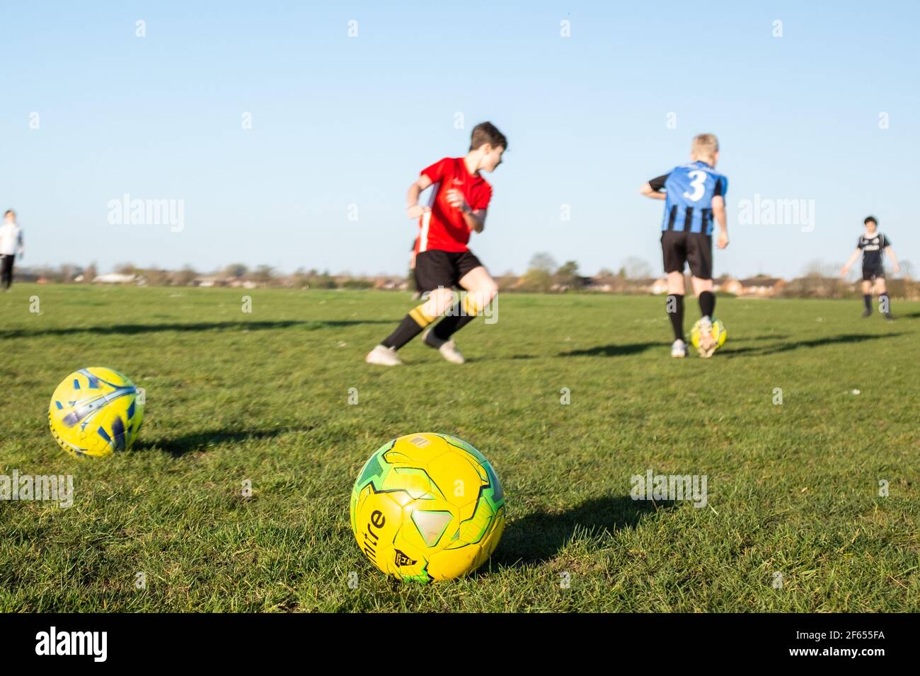 Junge Leute spielen am Frühlingsnachmittag eine Fußballtrainingseinheit Nach der dritten Sperre erlauben Beschränkungen die Teilnahme am 29th. März 2021 Stockfoto