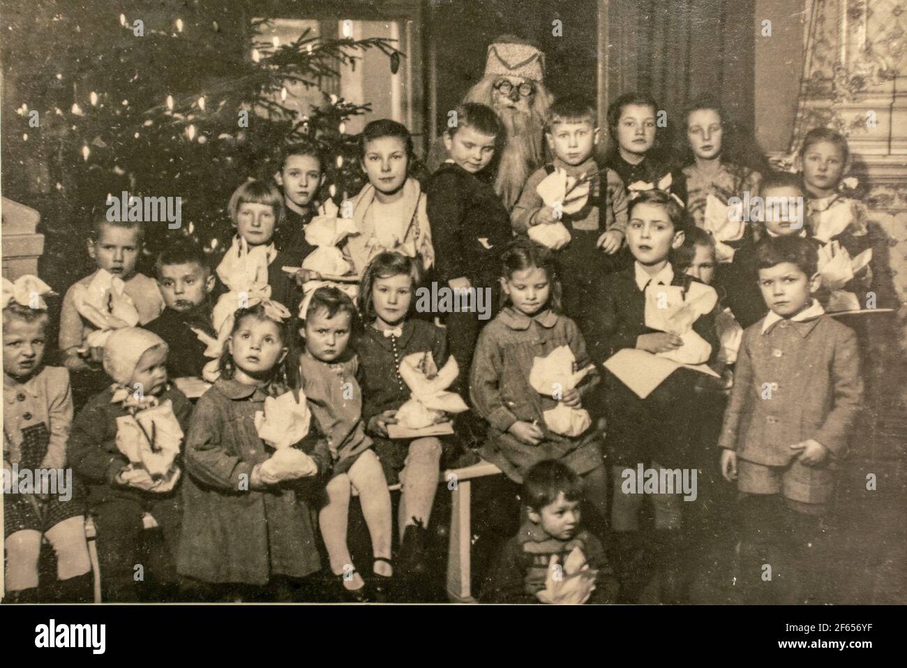 Deutschland - UM 1940s: Gruppenfoto von kleinen Kindern Mädchen Jungen und Weihnachtsmann auf Weihnachten Silvester Party. Vintage Archiv Art Deco Ära Fotografie Stockfoto