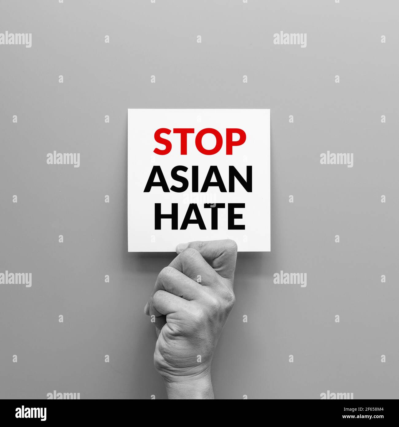 Stop Asian hate Konzept. Hand halten Karte Blatt mit Wort stoppen asiatischen Hass für Plakat der Kampagne. Stockfoto