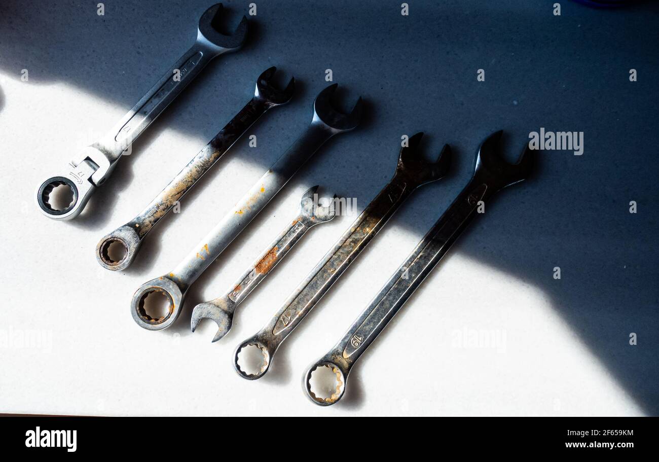 Alte und rostige Schraubenschlüssel-Werkzeuge auf der weißen Arbeitsplatte Stockfoto
