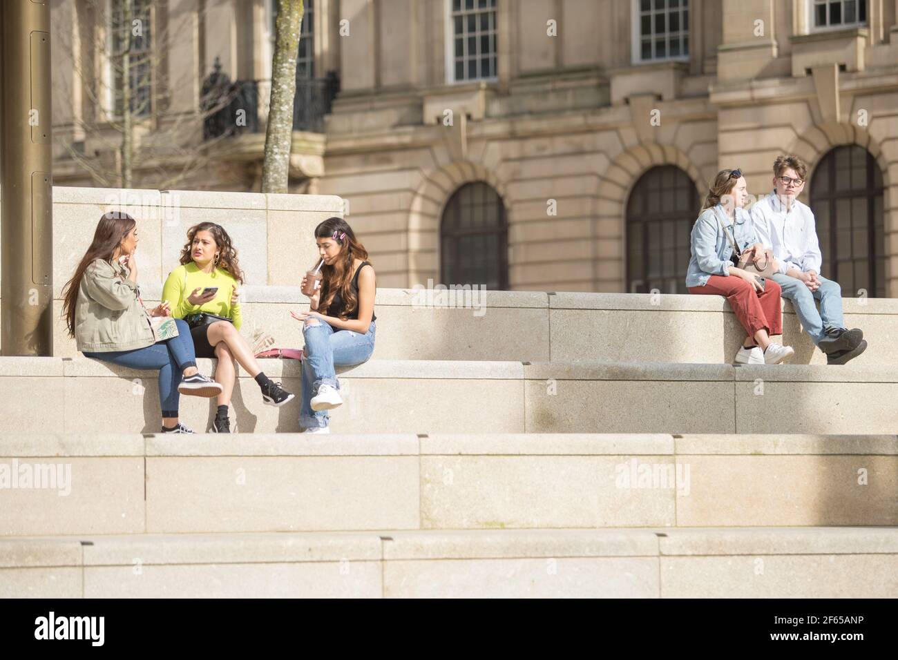 Birmingham, Großbritannien. März 2021, 30th. Büroangestellte entspannen sich in der Sonne auf dem neu entwickelten Chamberlain Square im Stadtzentrum von Birmingham. Kredit: Peter Lopeman/Alamy Live Nachrichten Stockfoto