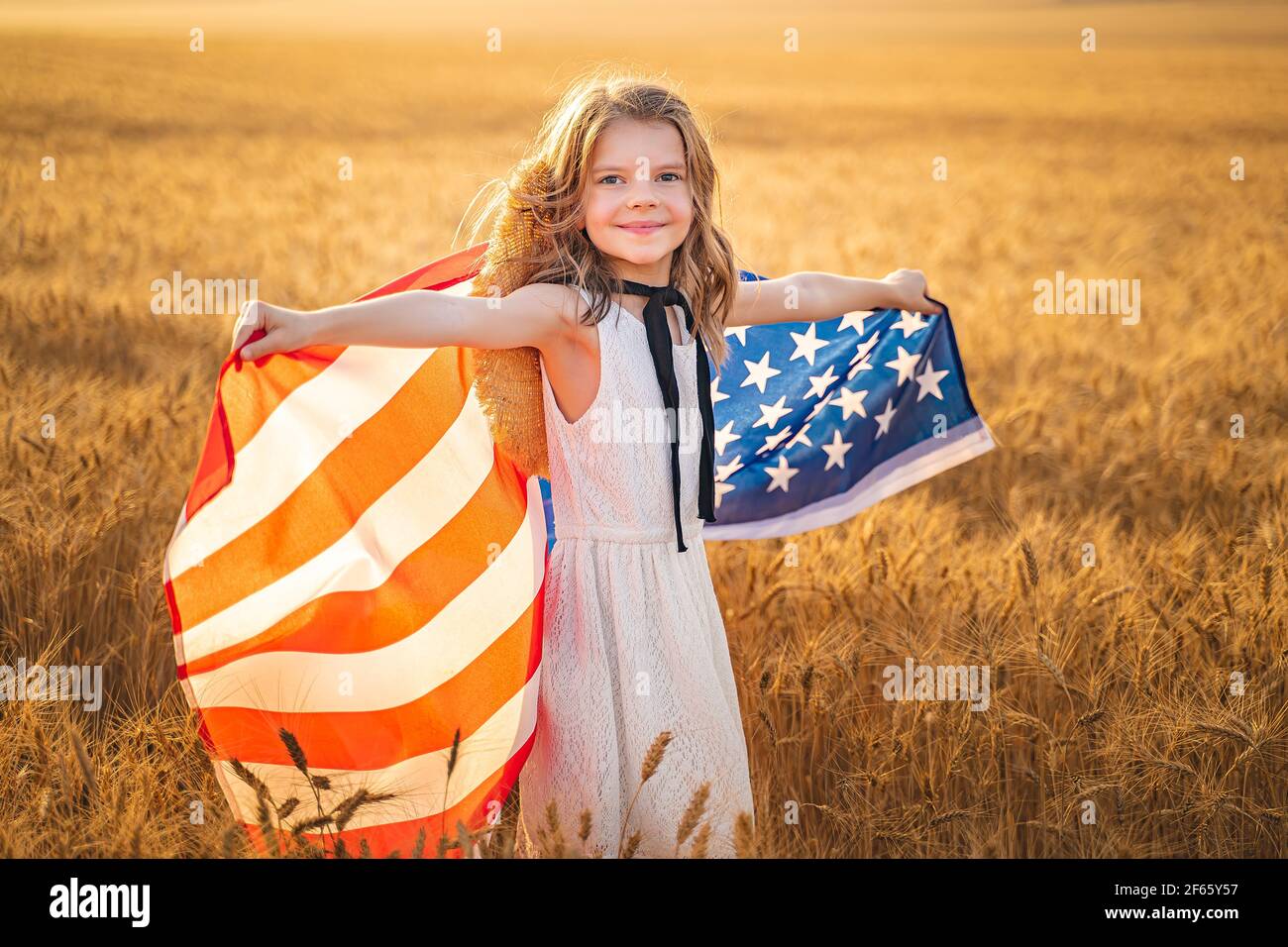 Liebenswert patriotischen Mädchen in weißem Kleid trägt eine amerikanische  Flagge Stockfotografie - Alamy