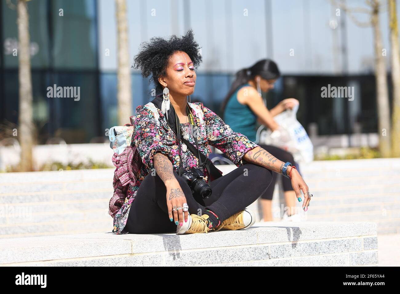 Birmingham, Großbritannien. März 2021, 30th. Eine junge Frau entspannt sich am Centenary Square im Stadtzentrum von Birmingham. Kredit: Peter Lopeman/Alamy Live Nachrichten Stockfoto