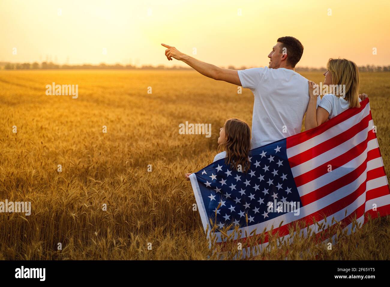 Glückliche Familie mit der Flagge von amerika USA bei Sonnenuntergang Im Freien Stockfoto