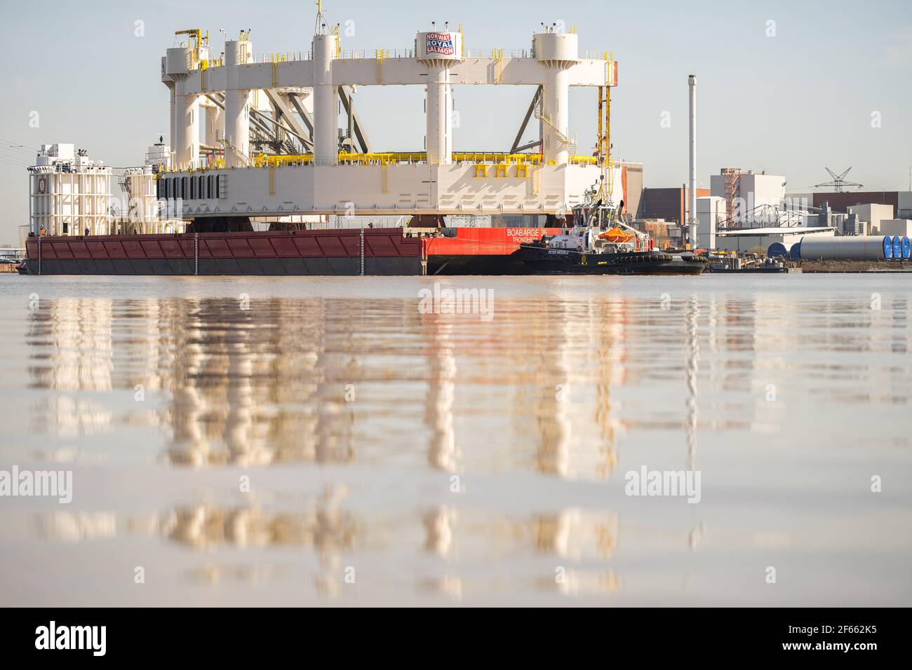 Emden, Deutschland. März 2021, 30th. Die 1600 Tonnen schwere Komponente für eine Tiefsee-Lachsfarm, die von der Emder Werft Fosen Yard gebaut wurde, wird von zwei Schleppern aus Emden Hafen auf einem Ponton transportiert und soll nach Norwegen transportiert werden. Kredit: Mohssen Assanimoghaddam/dpa/Alamy Live Nachrichten Stockfoto