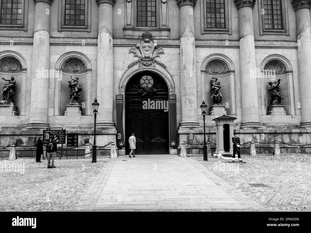 Wachen vor einer großen dunklen Tür des Königlichen Palastes (Kungliga Slottet) / Stockholms-Palasts (Stockholms Slott), Stockholm, Schweden. S/W Stockfoto