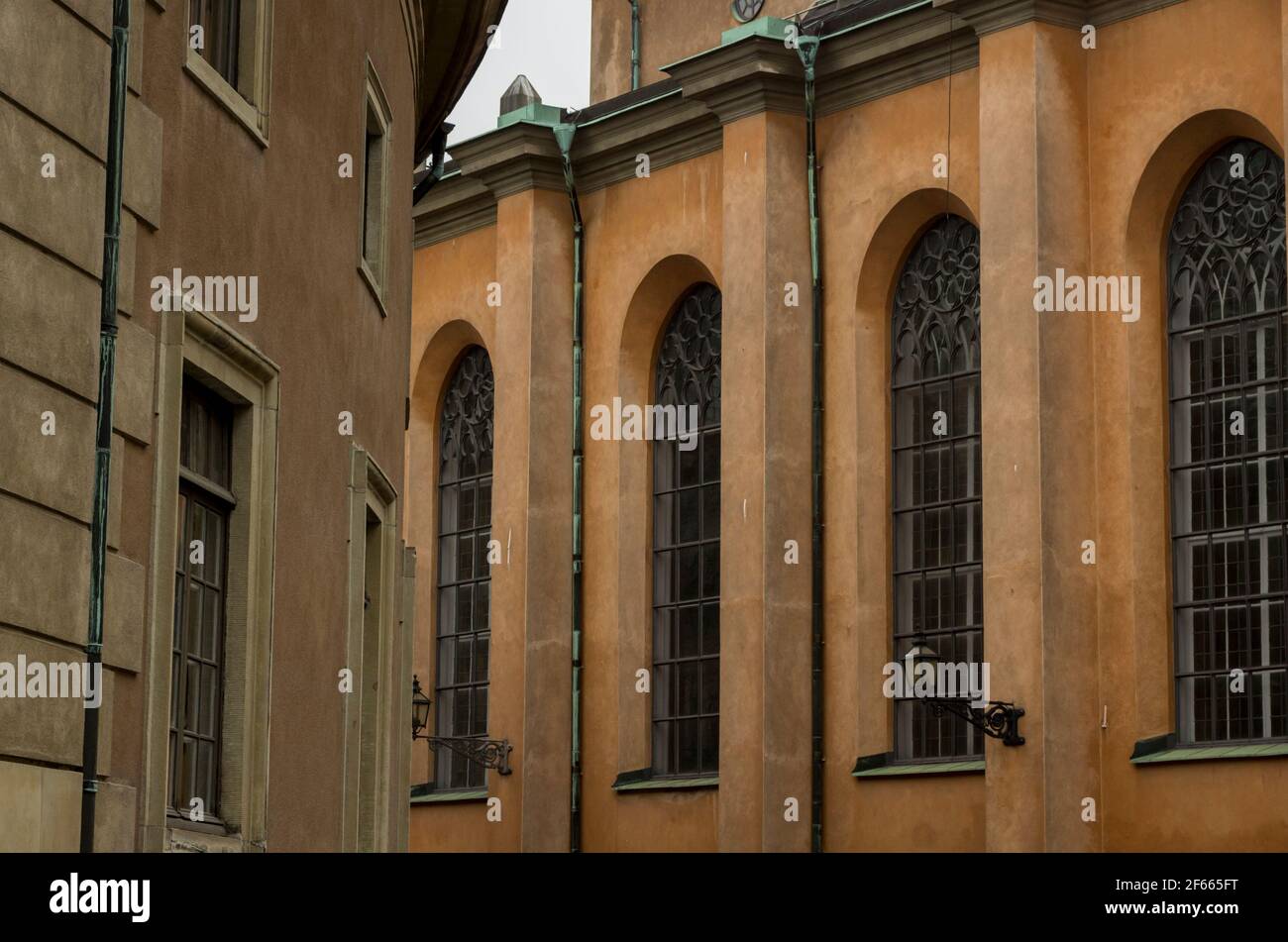 Detail der Storkyrkan (die große Kirche) / Stockholms Domkyrka (Stockholmer Kathedrale) mit hohen Fenstern in der gelb/orange gerenderten Fassade. Stockfoto