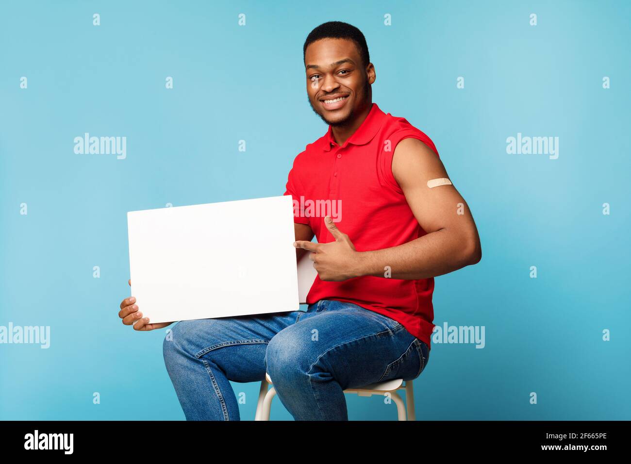 Geimpfter Mann Holding Poster Für Coronavirus-Impfung Ad, Blauer Hintergrund Stockfoto