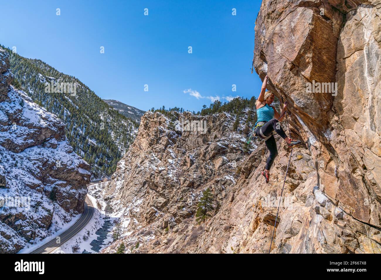 3/27/21 Golden, Colorado - Eine Frau arbeitet die Bewegungen auf einem steilen Felsklettern im Clear Creek Canyon aus. Stockfoto