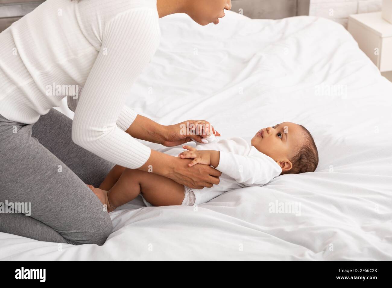 African Mama Tut Gymnastik Bis Baby Im Schlafzimmer, Abgeschnitten Stockfoto