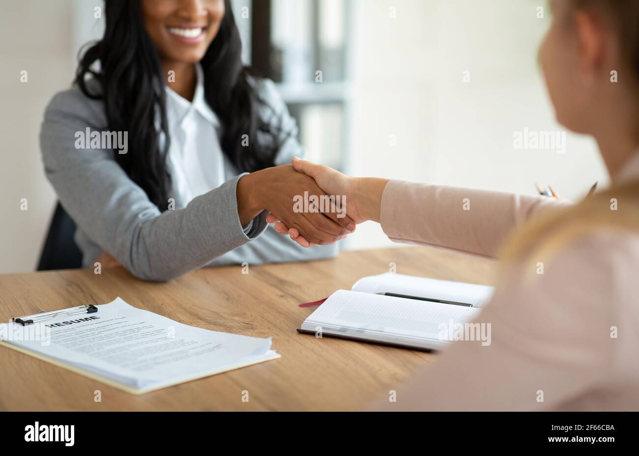 Beschnittene Ansicht des afroamerikanischen Personalmanagers, der die Hand schüttelt Stellenbewerber während des Vorstellungsgesprächs im Büro Stockfoto