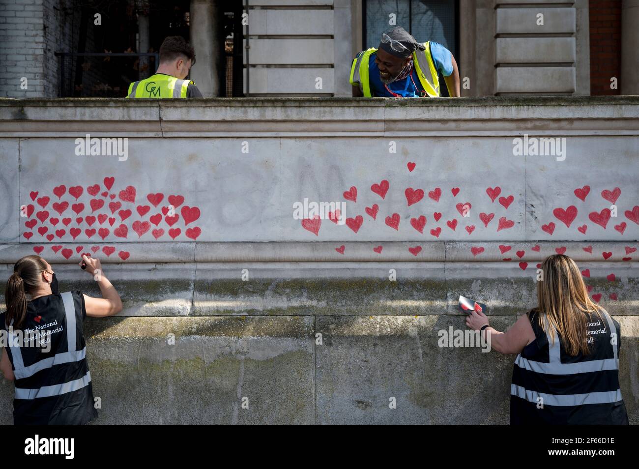 London, Großbritannien. März 2021, 30th. Freiwillige ziehen Herzen an eine Wand in Lambeth an der Themse, wobei jedes Herz jemanden repräsentiert, der während der laufenden Coronavirus-Pandemie in Großbritannien gestorben ist. Sie wurde von den Covid-19 Hinterbliebene Familien für Gerechtigkeit geschaffen und wird sich bis zur Fertigstellung für eine halbe Meile erstrecken. Kredit: Stephen Chung/Alamy Live Nachrichten Stockfoto